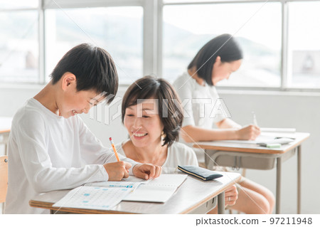 Senior Asian male student talking with a teacher in a school classroom / cram school (learning / education) Senior Asian male student talking with a teacher in a school classroom / cram school (learning / education) 97211948