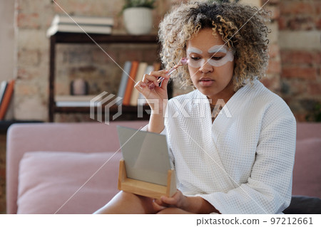 African American girl making skincare procedure with quartz roller African American girl making skincare procedure with quartz roller 97212661