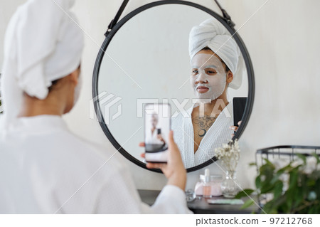 African American girl with smartphone taking selfie in front of mirror 97212768