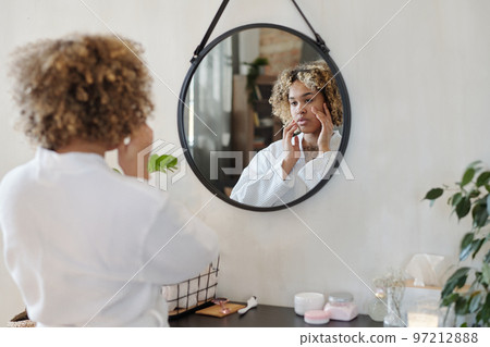 Young beautiful African American woman in white bathrobe 97212888