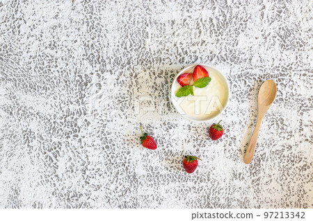 Top view of Strawberry yogurt in a wooden bowl with granola, mint and fresh strawberry on wooden background. Health food concept.. Top view of Strawberry yogurt in a wooden bowl with granola, mint and fresh strawberry on wooden background. Health food concept.. 97213342
