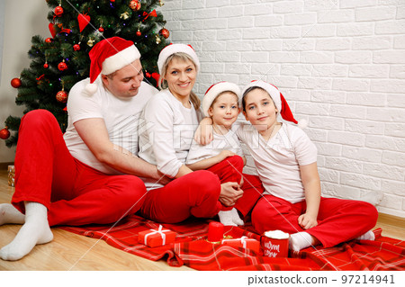 Portrait of happy family with Christmas gifts on floor. Cheerful family Portrait of happy family with Christmas gifts on floor. Cheerful family 97214941