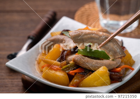 Eating pan-fried pork small intestine with pineapple. 97215350