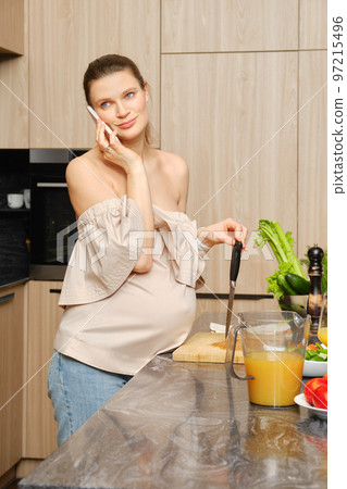 Pregnant woman making order for delivery of food ingredient by phone Pregnant woman making order for delivery of food ingredient by phone 97215496