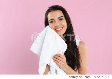 Young woman wiping face with towel on pink background 97215926