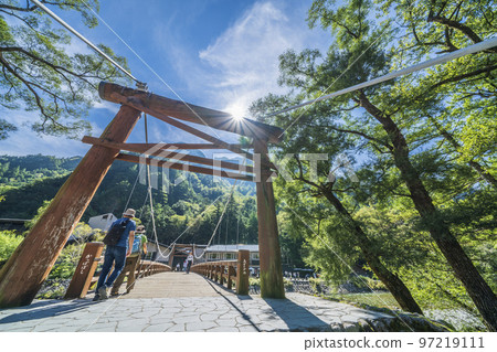 Kamikochi in summer with beautiful fresh greenery; Kappa Bridge with tourists passing by [Matsumoto City, Nagano Prefecture] 97219111