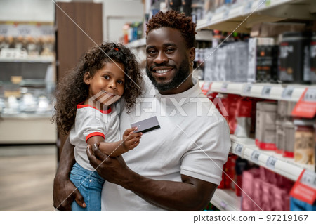 African american man holding his kid, the girl holding a credit card and smiling African american man holding his kid, the girl holding a credit card and smiling 97219167