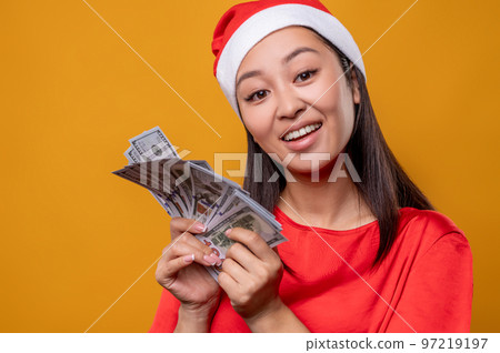 Young woman in santa hat with dollars in hands 97219197