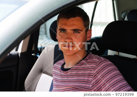Defocus happy smiling caucasian young man sitting in car. 20s guy looking from open window. Silver grey gray car. Attractive brunette men in vehicle. Buyer or dealer concept. Out of focus Defocus happy smiling caucasian young man sitting in car. 20s guy looking from open window. Silver grey gray car. Attractive brunette men in vehicle. Buyer or dealer concept. Out of focus 97219399