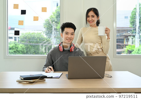 Two young creative people brainstorming, working together for design project at office 97219511