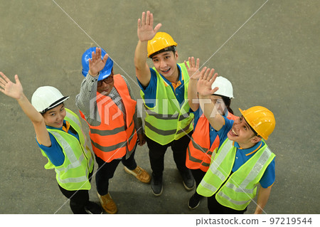 Overhead view of diverse warehouse workers celebrating success together. Logistics, and manufacture storehouse occupation concept Overhead view of diverse warehouse workers celebrating success together. Logistics, and manufacture storehouse occupation concept 97219544