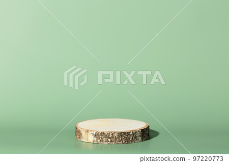 Wood slice podium on green background for cosmetic product mockup 97220773