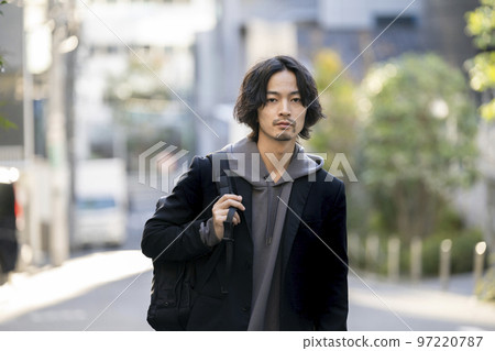 一個 30 歲出頭的男人背著背包看著相機肖像 97220787
