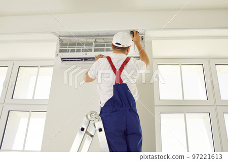 Professional technician worker is checking up, testing, repairing air conditioner indoors. Professional technician worker is checking up, testing, repairing air conditioner indoors. 97221613