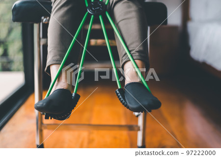 Elderly woman doing exercises and stretching for treatment with a rubber resistance bands 97222000