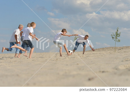 Family playing football on a beach in summer day Family playing football on a beach in summer day 97222084