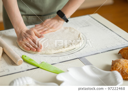 Woman hands with electronic bracelet cooking pastry on silicone baking mat with markings and tips 97222468