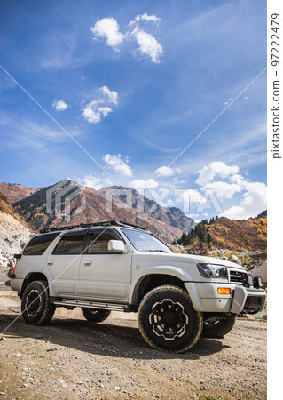 White off-road car in scenic mountains, copy space in sky, vertical White off-road car in scenic mountains, copy space in sky, vertical 97222479