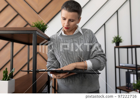 woman specialist stands with papers and documents on the background of the office 97222716