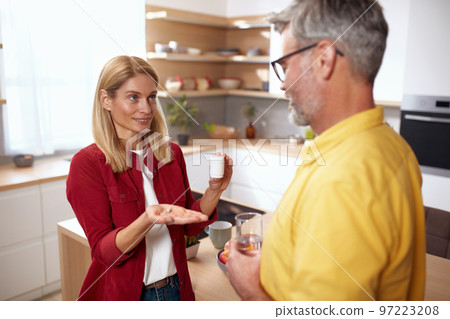 Smiling Couple Drinking Vitamins. Cheerful Lady Giving Vitamins To Husband Smiling Couple Drinking Vitamins. Cheerful Lady Giving Vitamins To Husband 97223208
