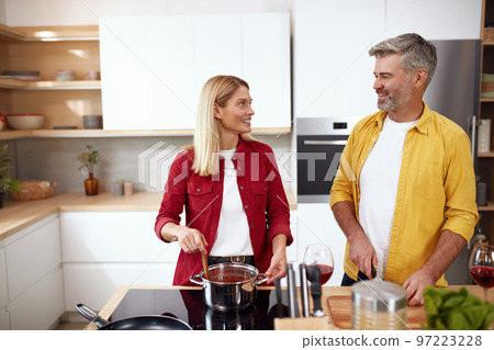 Couple Cooking At Kitchen. Senior Positive Man Cutting Vegetables For Salad Couple Cooking At Kitchen. Senior Positive Man Cutting Vegetables For Salad 97223228