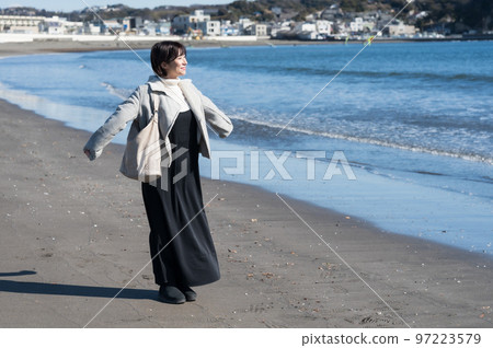 Woman taking a deep breath in the winter sea 97223579