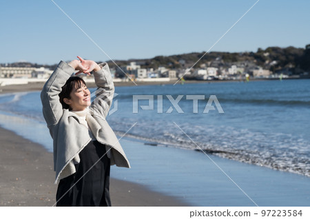 Woman taking a deep breath in the winter sea 97223584