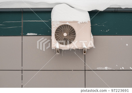 An outdoor air conditioner unit installed on the outer wall of a building An outdoor air conditioner unit installed on the outer wall of a building 97223691