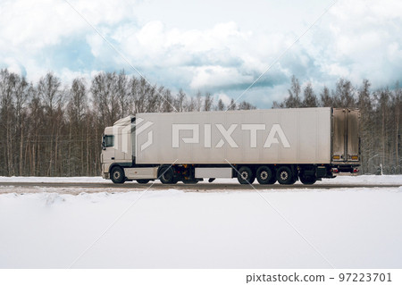 Truck driving on the winter road in rural landscape 97223701