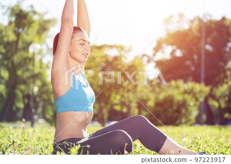 Smiling woman training outdoor at sunny day 97223917