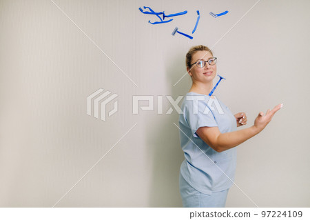 a female laser hair removal master in a blue robe throws shaving machines on a light background a female laser hair removal master in a blue robe throws shaving machines on a light background 97224109