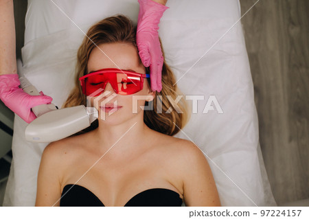 A girl in black underwear gets laser hair removal on her body in the salon A girl in black underwear gets laser hair removal on her body in the salon 97224157