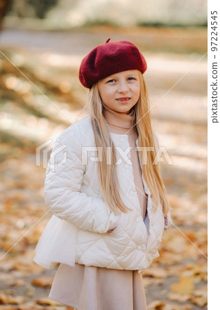 A happy girl in a cap walking in the autumn park 97224545