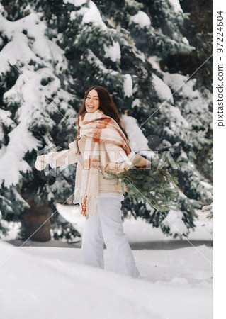 A girl in a winter forest with a bouquet of fir branches. Snowy winter 97224604
