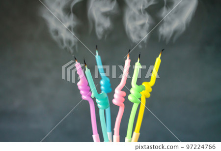 Birthday candles with flame blown out smoke on dark background Birthday candles with flame blown out smoke on dark background 97224766