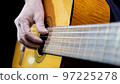 Guitarist playing acoustic guitar on black background, selective focus. 97225278