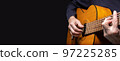 Guitarist playing acoustic guitar on black background, selective focus. 97225285