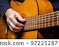 Guitarist playing acoustic guitar on black background, selective focus. 97225287