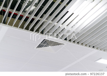 Ceiling mounted cassette type air conditioner and modern lamp light on white ceiling. duct air conditioner for home or office 97226137