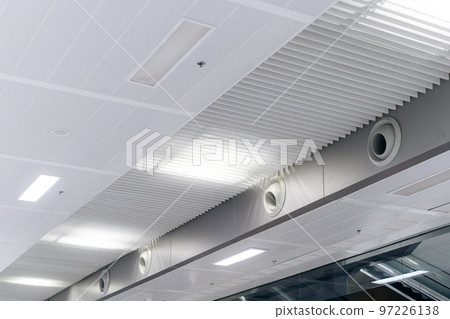 Ceiling mounted cassette type air conditioner and modern lamp light on white ceiling. duct air conditioner for home or office 97226138