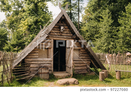 Triangular log houses with wooden roofs behind a fence. Montenegro, north Triangular log houses with wooden roofs behind a fence. Montenegro, north 97227080