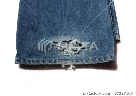 Broken blue jeans hem on white background 97227166