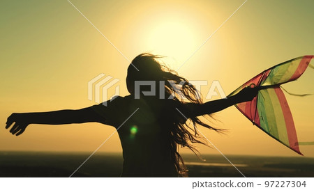 kite. colored rainbow kite hands girl with long hair. happy family. chidhood dream. girl park sunset playing with kite. child teenager journey. fantasy child. concept kite wind. play game nature. kite. colored rainbow kite hands girl with long hair. happy family. chidhood dream. girl park sunset playing with kite. child teenager journey. fantasy child. concept kite wind. play game nature. 97227304