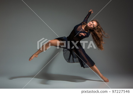 Dancing woman in a black dress. Contemporary modern dance on a gray background. 97227546
