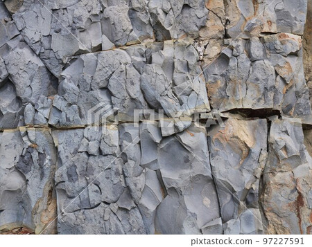 texture background of a gray rock with a rough surface of a monolithic stone with cracks, bends and bulges of natural origin, rocky space as a background 97227591