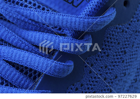 Fragment of a blue sneaker with drawstring macro.Sneaker texture Fragment of a blue sneaker with drawstring macro.Sneaker texture 97227629