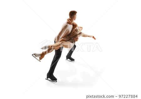 Ice dancing. Portrait of young man and woman, figure skating athletes performing isolated over white studio background Ice dancing. Portrait of young man and woman, figure skating athletes performing isolated over white studio background 97227884