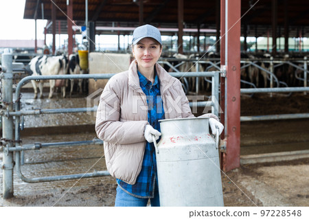 Portraif of woman dairy farm worker with milk can 97228548