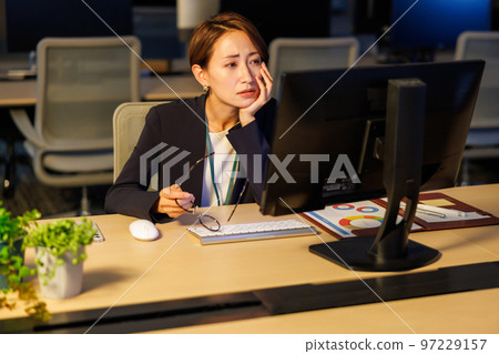 留在公司工作到很晚的女商人 留在公司工作到很晚的女商人 97229157