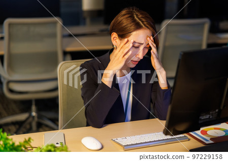 Business woman staying in the company and working late 97229158